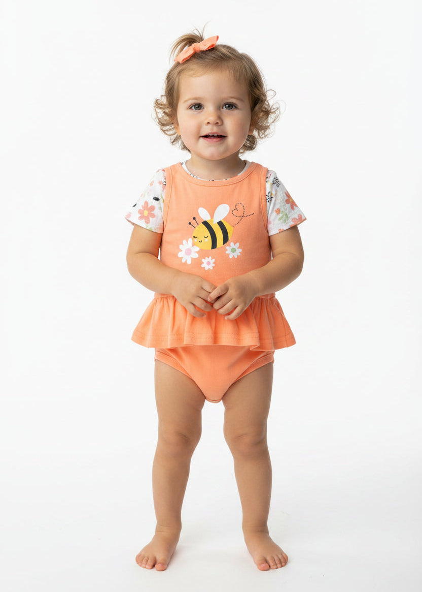 Baby outfit with orange top and bloomers featuring a bee design, hanging against a red background.